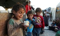 Một em bé Syria nâng niu suất ăn là một mẩu rau súp lơ. Ảnh: Getty 