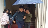 Chị Đỗ Thị Hoài San dìu con đi học Ảnh: PV 