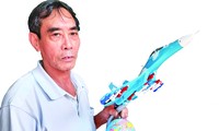 Ông Bùi Xuân Thành với chiếc máy bay chiến đấu mô hình đã hoàn thành Ảnh: Nguyễn Thành