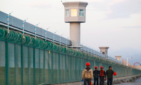 Một nhóm công nhân đi dọc hàng rào của trung tâm cải tạo ở Tân Cương Ảnh: Reuters