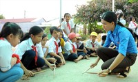 Cô Thạch Thị Bút Pha hướng dẫn học sinh tập gõ, đánh các bài trống Đội trên nền sân trường. Ảnh: Xuân Tùng