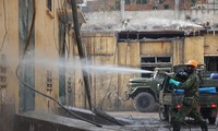 Chiến sĩ phòng hóa dùng súng phun hóa chất tẩy độc các bức tường 