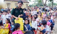 Đại úy Trần Duy Văn trao quà tặng học sinh ở xã Cẩm Lương, huyện Cẩm Thủy (Thanh Hóa) bị ảnh hưởng nặng nề do lũ lụt, năm 2018 