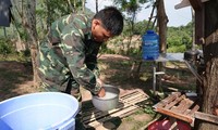 Trung úy Nguyễn Giai Hưng vo gạo nấu cơm trưa tại chốt chống dịch trên bến Cổ Thành ẢNH: NGUYỄN MINH 