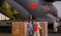 Các nhân viên y tế Philippines dỡ lô vắc-xin do máy bay quân sự Trung Quốc đưa đến ảnh: Reuters 