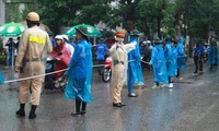 Nữ cảnh sát giao thông đội mưa làm nhiệm vụ tại điểm thi