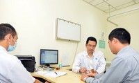 Bác sĩ Thành đang khám cho bệnh nhân bị tê tay do dùng các thiết bị điện tử thời gian dài trong ngày. Ảnh:Khánh Trung.