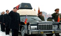 Lãnh đạo Triều Tiên Kim Jong-un (trái) đứng bên cạnh chiếc xe Lincoln Continental chở quan tài cố lãnh tụ Kim Jong-Il. Ảnh: AP.