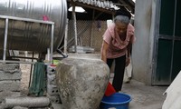 Bà Vang Thị Kim chắt chiu từng giọt nước quý giá mà bà đi xin được Ảnh: PV