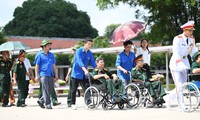 Hình ảnh thanh niên ân cần hỗ trợ các thương binh nặng về thăm Hà Nội
