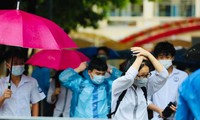 Thí sinh đội mưa đến điểm thi ở Hà Nội ngày 13/6. Ảnh: Như Ý 
