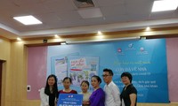 Đại diện NXB và tác giả Tăng Quang (áo trắng) tặng quà trích từ tiền bán sách cho những phụ nữ yếu thế bị ảnh hưởng bởi dịch COVID-19 
