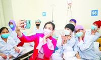 Hoa hậu Đỗ Thị Hà chụp ảnh cùng các bệnh nhân khi thăm tặng quà tại Viện Huyết học và Truyền máu T.Ư Ảnh: Như Ý