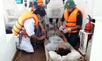 Bộ đội Biên phòng và nhân viên y tế cấp cứu ngư dân gặp nạn ngay trên biển. Ảnh: NGỌC BÌNH