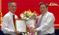 Ông Lữ Văn Hùng (trái) nhận quyết định và hoa chúc mừng của Trưởng ban Tổ chức Trung ương Phạm Minh Chính -Ảnh: Zing.vn