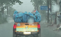 Hình ảnh xúc động: Cán bộ y tế mặc đồ bảo hộ khoác vai nhau dưới trời mưa tầm tã