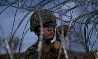 Một binh sĩ nhìn qua hàng rào dây thép gai tại biên giới Mexico-Mỹ. Ảnh: AP