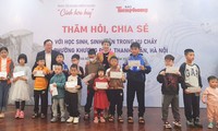 Tổng biên tập Báo Tiền Phong Lê Xuân Sơn và ca sĩ Ngọc Khuê trao quà cho các em nhỏ