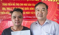 Ông Phan Huy Hoàng, Giám đốc Quỹ hỗ trợ ngư dân Quảng Ngãi trao tiền hỗ trợ cho thuyền trưởng Trần Hồng Thọ - ảnh V.C 
