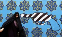 Một phụ nữ Iran đi qua bức tranh trên tường Đại sứ quán cũ của Mỹ tại Tehran. Ảnh: AFP