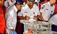 Các quan chức Indonesia xem xét chiếc hộp đen (màu da cam) được đựng trong thùng nước tại cảng Jakarta. Ảnh: CNA