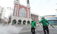 Nhân viên vệ sinh khử trùng khu vực bên ngoài một nhà thờ ở Seoul. Ảnh: Yonhap