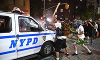 Người biểu tình đập phá xe cảnh sát New York. Ảnh: Getty