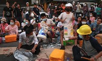 Người biểu tình Myanmar ngồi gõ nắp vung, thùng nhựa trên phố ngày 14/3. Ảnh: Reuters