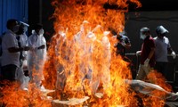 Thân nhân mặc đồ bảo hộ khi một bệnh nhân COVID-19 được hỏa thiêu ở New Delhi ngày 21/4. Ảnh: Reuters