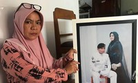 Bà Yayak Dwi Ernawati cầm ảnh cưới của con gái và con rể - thủy thủ tàu ngầm KRI Nanggala-402. Ảnh: CNA