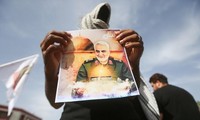 Một binh sĩ cầm ảnh chân dung của Tướng Qassem Soleimani. Ảnh: Reuters