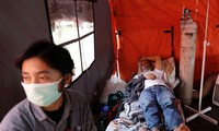 Một bệnh nhân COVID-19 được điều trị trong lều tạm ở Jakarta. Ảnh: Reuters