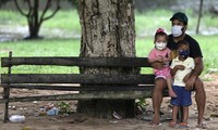 Một gia đình người Brazil đứng trước cơ sở tiêm chủng. Ảnh: Reuters