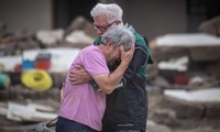 Hai anh em đau buồn khi đứng trước căn nhà bị phá huỷ của cha mẹ ở Altenahr (Đức). Ảnh: CNN