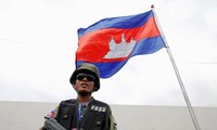 Quân nhân Campuchia đứng dưới quốc kì ở thủ đô Phnom Penh. Ảnh: Reuters
