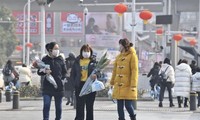 Người đi trên phố ở Vũ Hán đeo khẩu trang để phòng lây nhiễm coronavirus mới. Ảnh: China Daily.