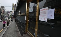 Một cặp đôi đeo khẩu trang bước ngang một hộp đêm đóng cửa ở Itaewon hôm 10/5. Ảnh: Getty Images.