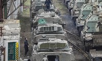 Ngày 23/2, binh sĩ Nga với đầy đủ quân trang được nhìn thấy đang bước qua bùn trên sân ga ở Rostov-on-Don, miền nam nước Nga gần biên giới với Ukraine. Các toa tàu chứa đầy xe bọc thép. Ảnh: EPA.
