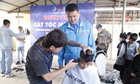 Thanh niên tình nguyện cắt tóc miễn phí cho trẻ em. Ảnh: Nguyễn Thắng