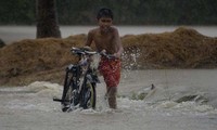 Cậu bé dắt xe đạp trên phố ngập nước ở Ineangan, Bambang, Nueva Viscaya