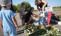 Dân làng đặt di ảnh một số hành khách xấu số của MH17 tại một khu tưởng niệm ở làng Petropavlivka, Donetsk, Ukraine