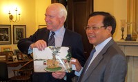 Ông Phạm Quang Nghị trao tặng Thượng nghị sĩ John McCain bức ảnh chụp bia chứng tích bên hồ Trúc Bạch (Ảnh: HNM)