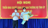 Ông Nguyễn Thanh Nam, Trưởng Ban Tổ chức Tỉnh ủy Bình Thuận trao quyết định và tặng hoa cho anh Lâm Hồng Tuyên.