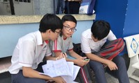 Thí sinh tại điểm thi THCS Trường Chinh, TPHCM trao đổi đề thi 