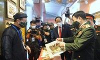 Đại tướng Phan Văn Giang thích thú chia sẻ với Phó Chủ tịch Quốc hội Trần Quang Phương về bức tranh Đông Hồ do tự tay mình làm tại khu vực Không gian văn hóa. Ảnh: Nguyễn Minh
