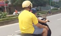 Người đàn ông để bé trai điều khiển xe máy trên phố Hà Nội