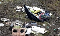 Nhân viên cứu hộ ngồi bên các mảnh vỡ của máy bay. Ảnh: Reuters.
