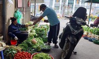 Cơ quan chức năng có nhiều giải pháp ngăn giá hàng hóa “té nước theo mưa” khi lương tăng. Trong ảnh, người dân mua hàng hóa tại chợ truyền thống ở Hà Nội