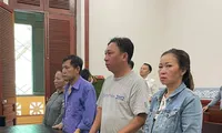 Cựu cán bộ công an Phạm Quang Tiến (áo xanh, thứ 3 phải sang) tại phiên tòa,