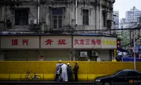 Các công nhân sửa lại rào chắn ở Vũ Hán, tỉnh Hồ Bắc. (Ảnh: Reuters)